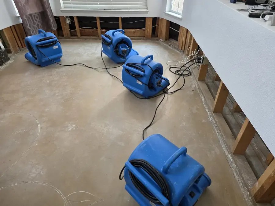 Air movers and a dehumidifier running in a Spokane home during structural drying